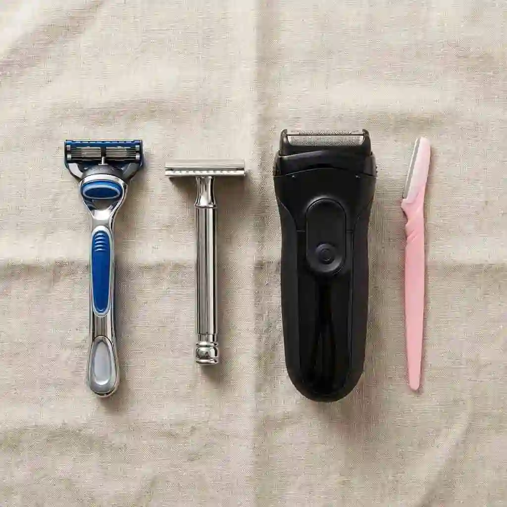 A flat lay display of various shaving tools including safety razors and cartridges, helping you choose the right instrument for how to get the cleanest shave based on your specific skin type needs.