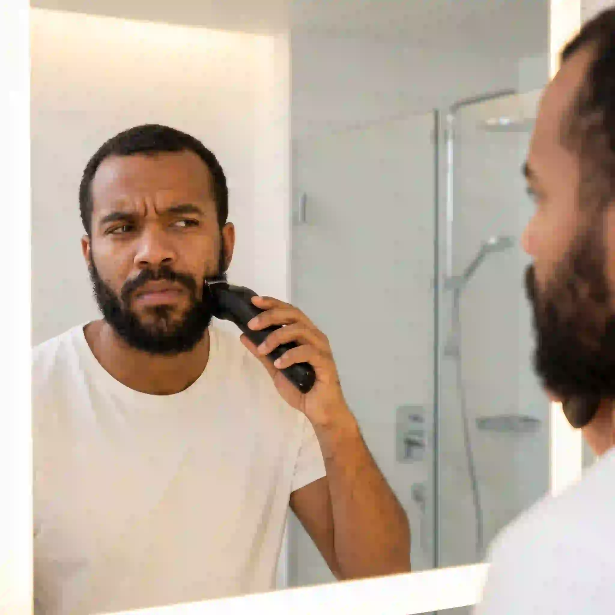 A man struggling with grooming issues who can greatly benefit from using a precise and easy to use beard liner tool to achieve perfect symmetry and avoid the frustrating cycle of over-trimming his facial hair.