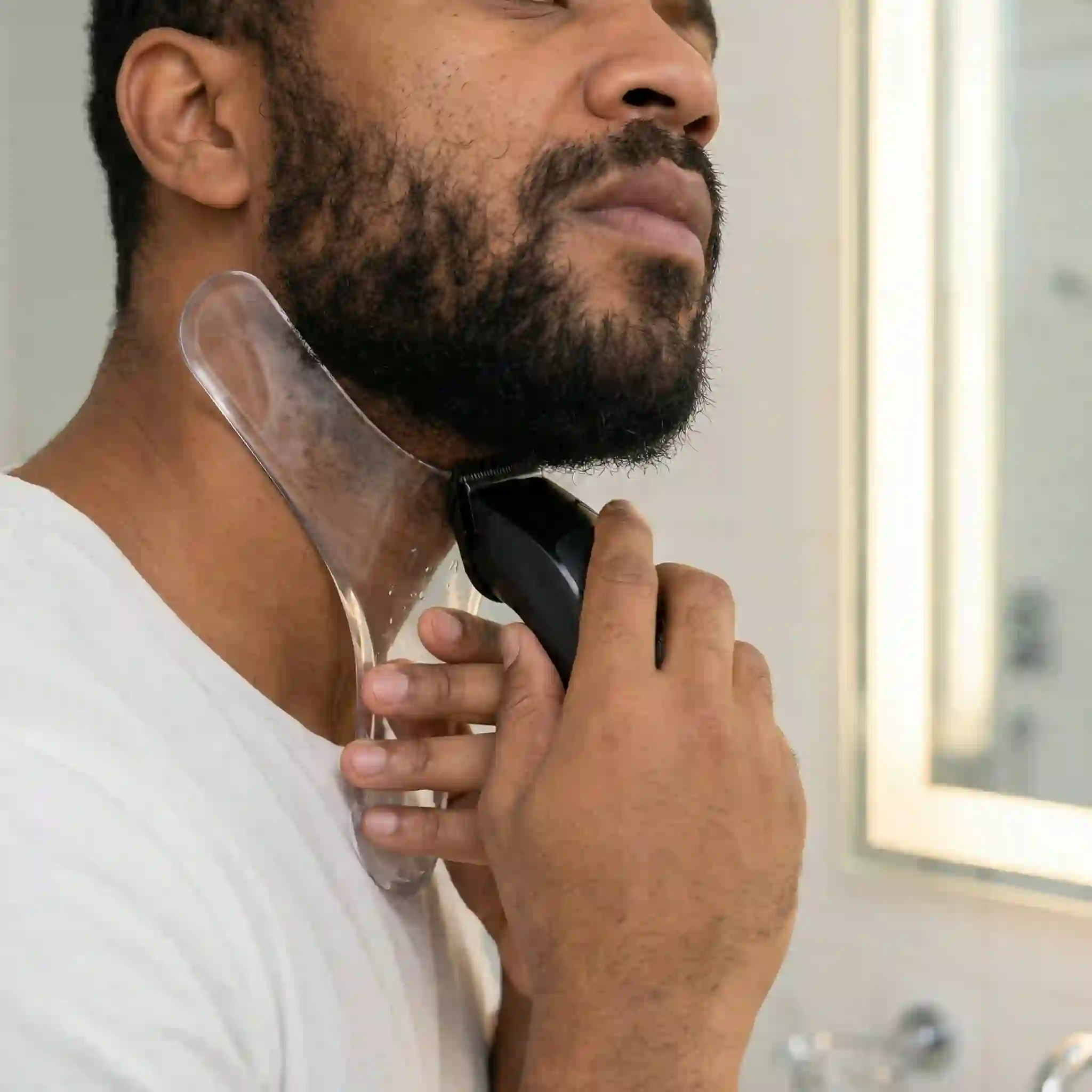 Holding your beard liner tool firmly in place along the designed curve allows you to confidently trim away all hair below the guide, instantly improving your appearance with a flawless, professional neckline.