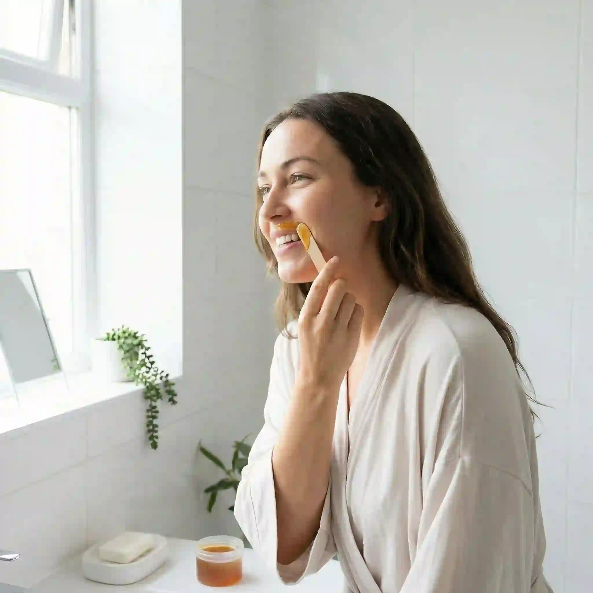 Waxing facial hair removal for women showing warm wax applied to skin for weeks-long smooth results on upper lip